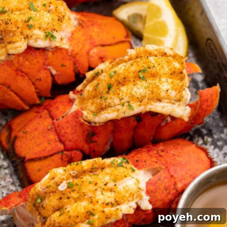 Four bright red lobster tails cooked in an Instant Pot then butterflied and set on a baking sheet.