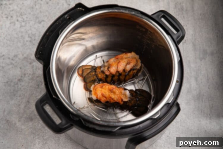 Overhead view of seasoned lobster tails in an Instant Pot on a trivet.