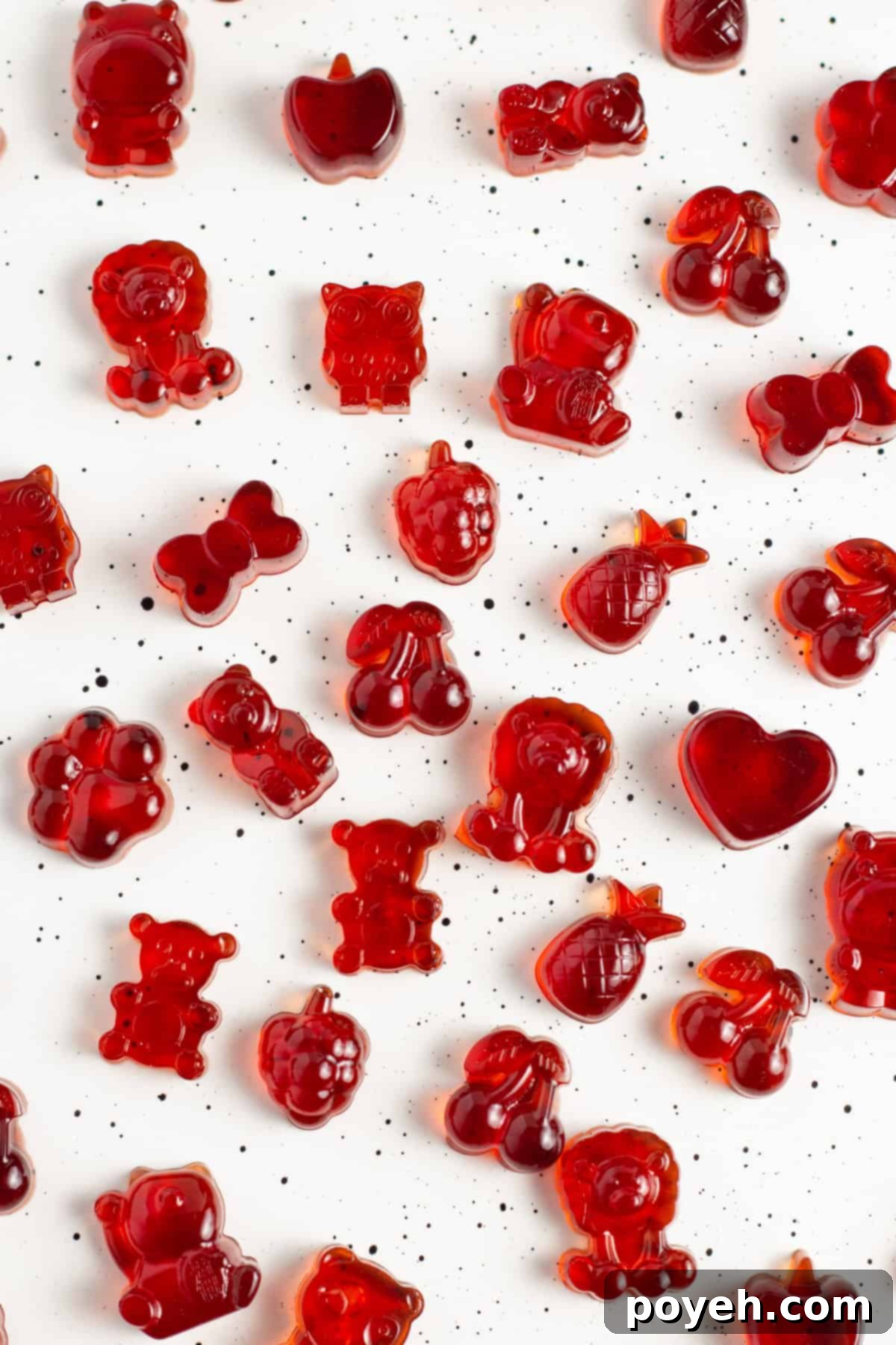 Sour Cherry Chews 4 Overhead view of bright red tart cherry gummies spread out on a white countertop.