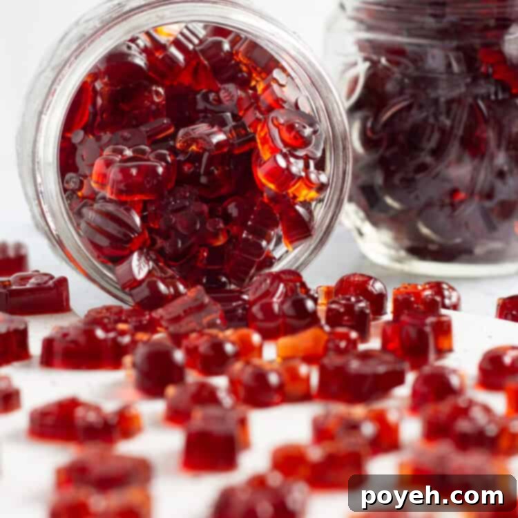 Sour Cherry Chews 6 Side view of a jar of tart cherry gummies, with cherry gummies spilling out onto a white countertop.