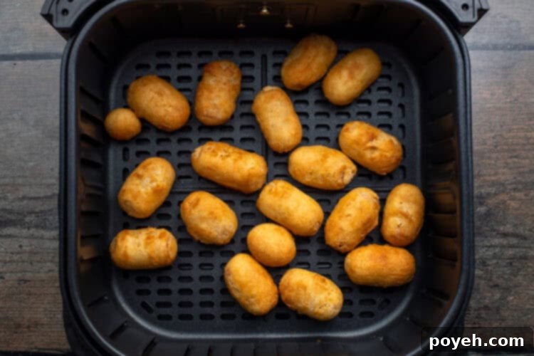 Finished air fryer mini corn dogs on a plate, ready to be served.