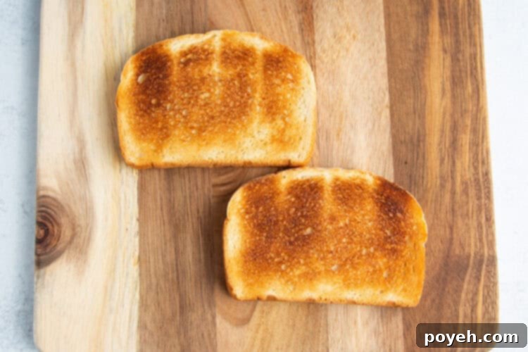 Two slices of toasted bread on a wooden cutting board.