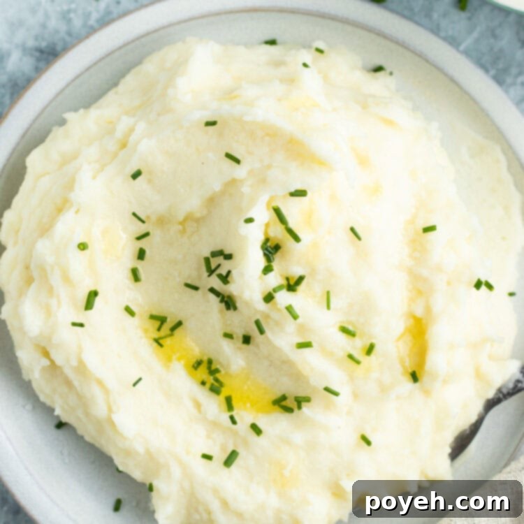 Overhead view of a pile of potato mousseline on a white plate next to a casserole dish of potatoes.