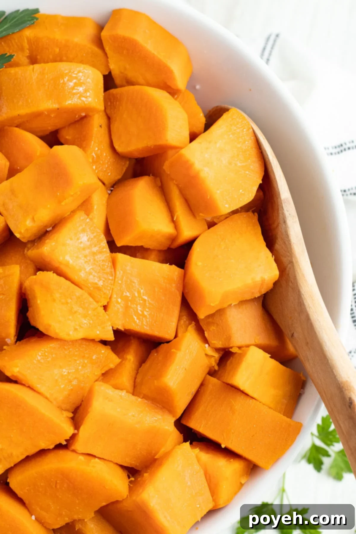 Overhead view of a large white bowl of cubed sweet potatoes, showing how to boil sweet potatoes for the holidays.