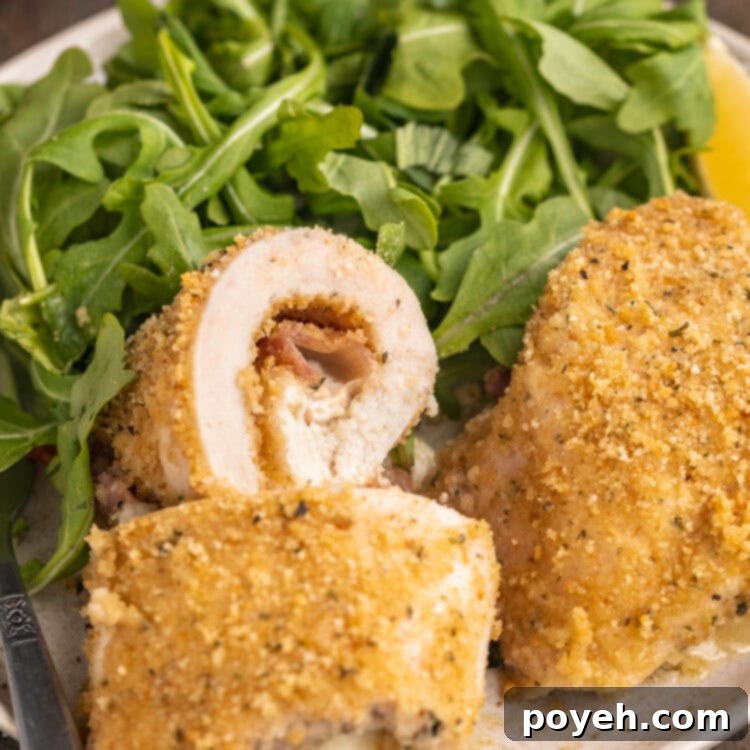 Overhead angled view of chicken rollatini plated with broccoli on a round plate.