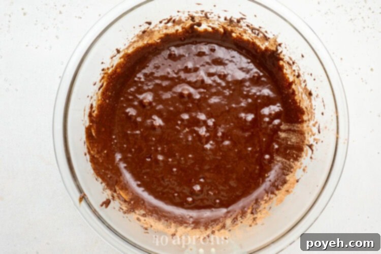 Brownie batter in a large glass mixing bowl.