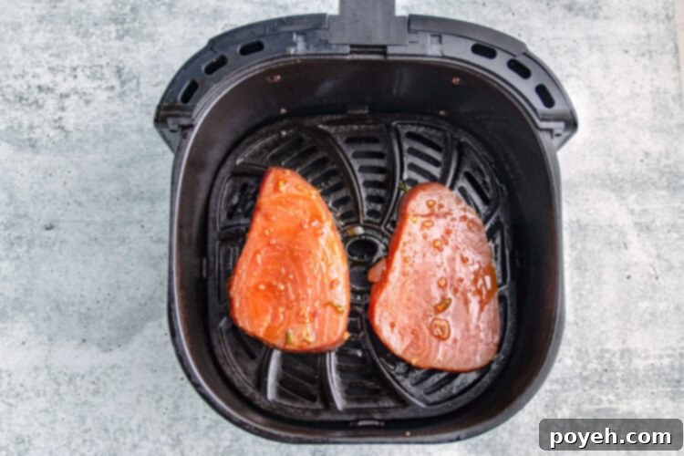Ahi tuna steaks in an air fryer basket.