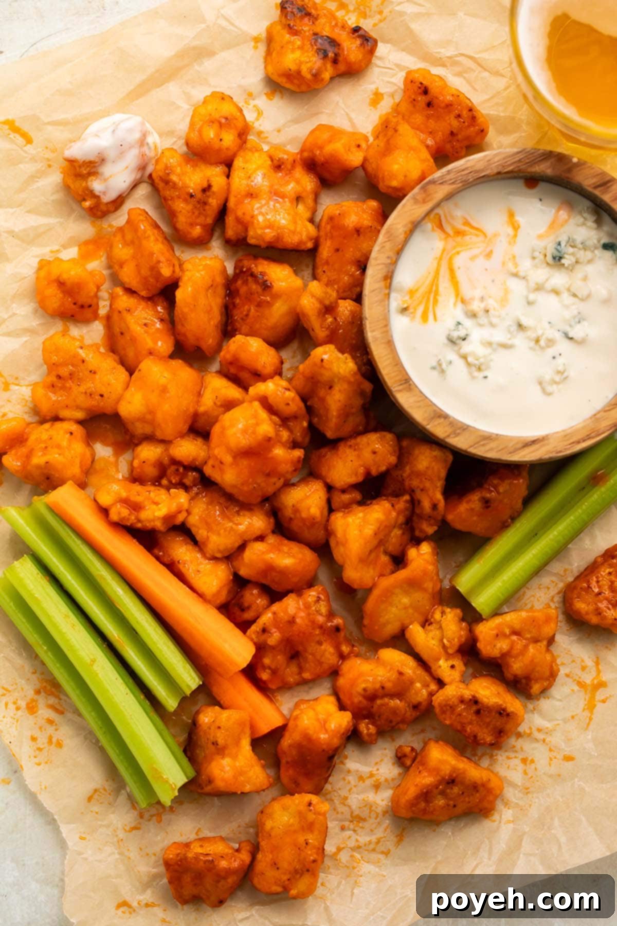 Close-up of baked buffalo tofu bites, showing their crispy texture and vibrant orange sauce.