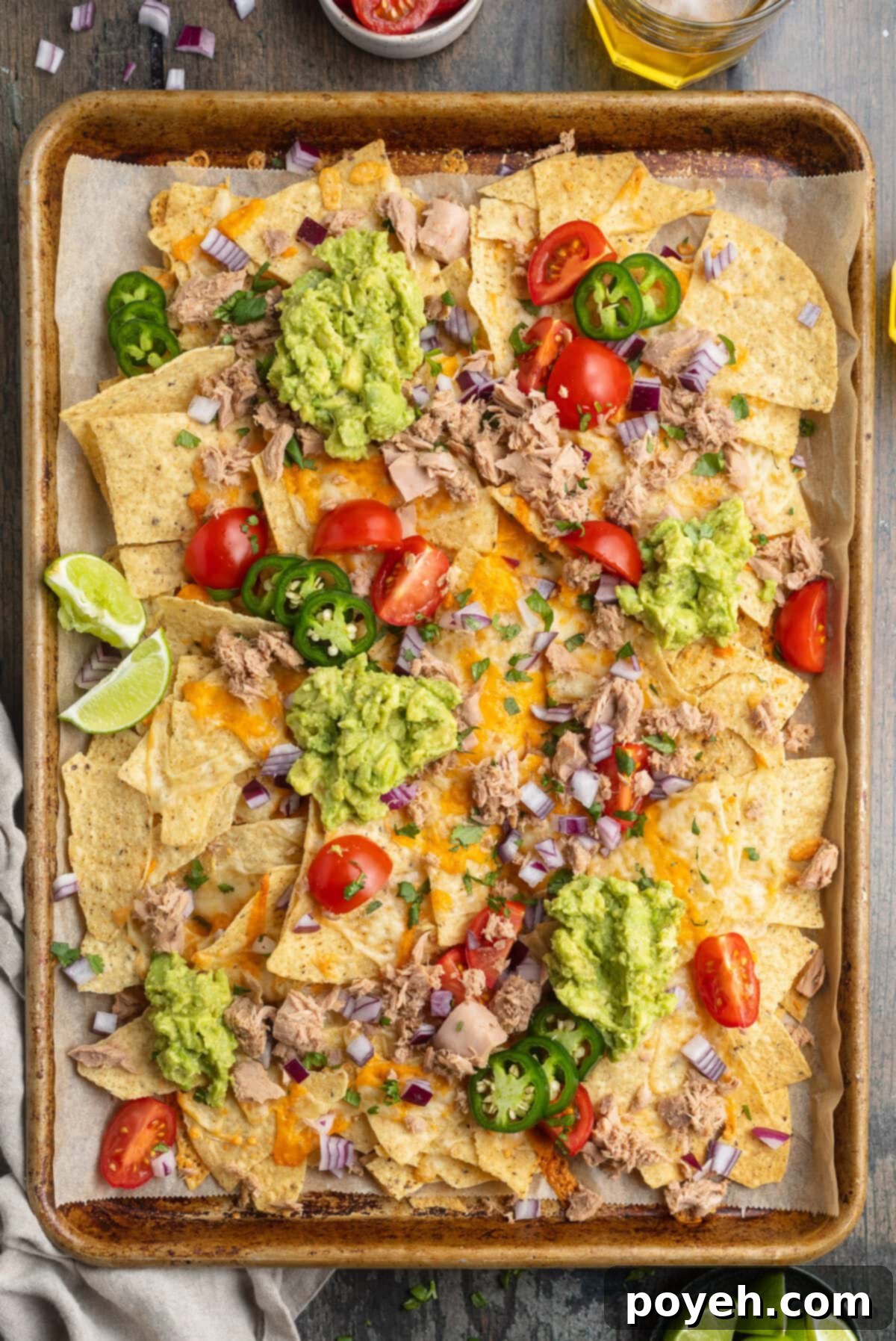 Overhead view of a large sheet pan covered with tuna nachos.
