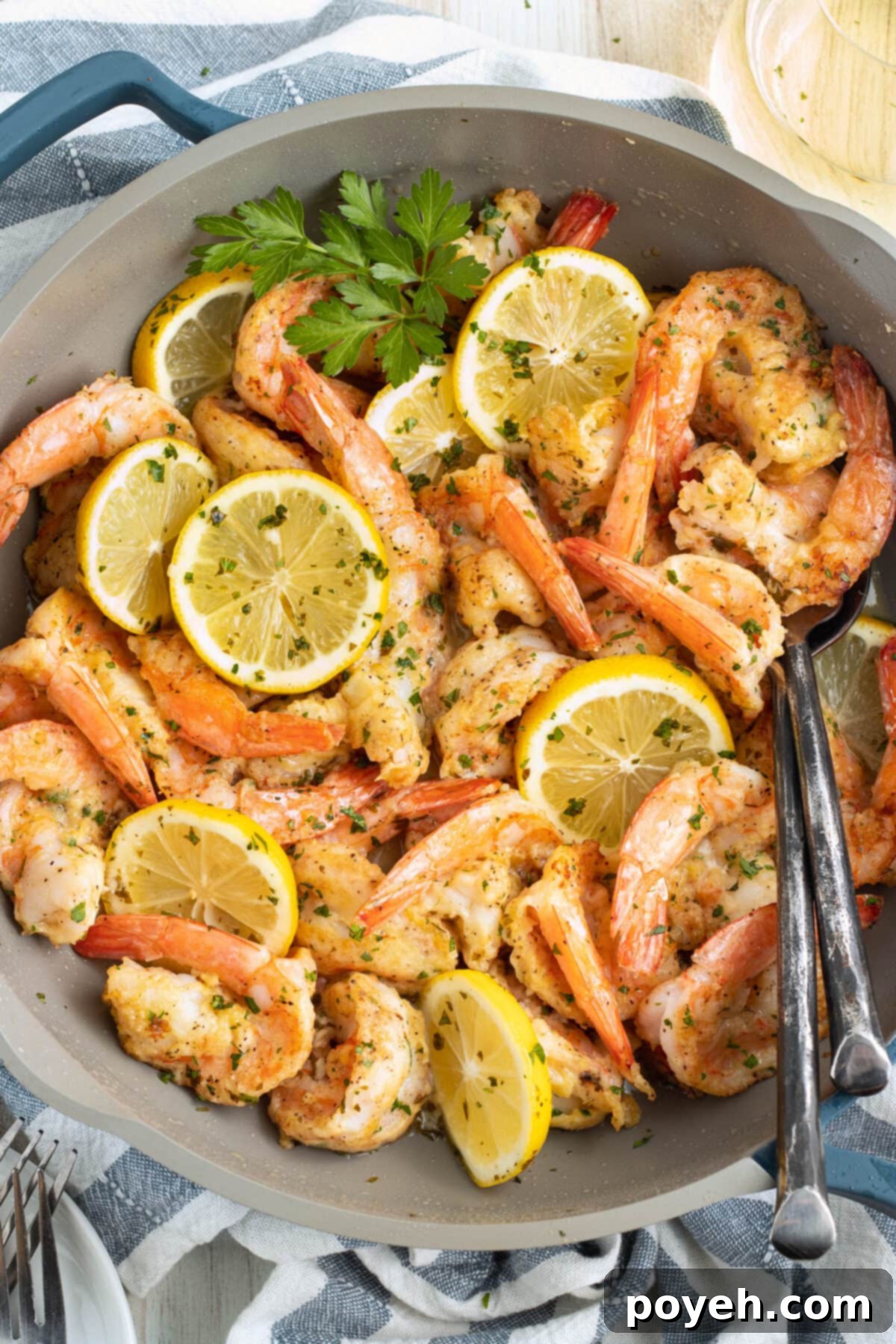 Shrimp francese in a large skillet, glistening with lemon and butter sauce.