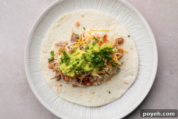 Carnitas burrito on a white plate.