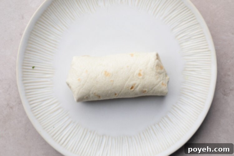 Carnitas burrito on a white plate.