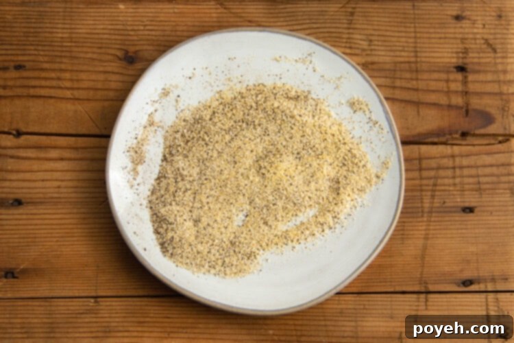Salt, garlic powder, and pepper blend on a shallow plate.