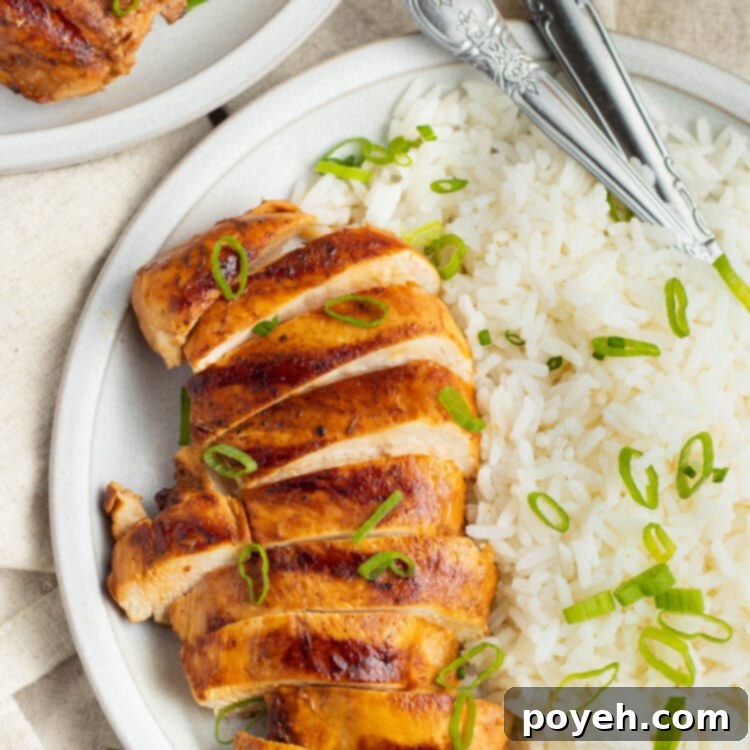 Top-down view of grilled chicken adobo, sliced and arranged on a platter with rice.
