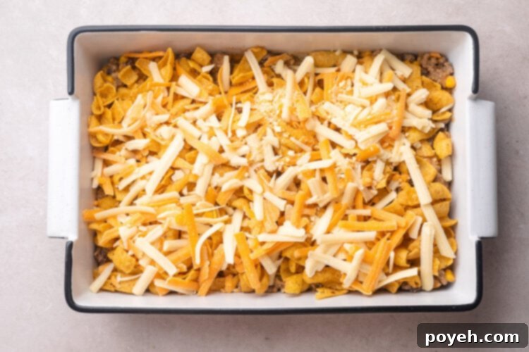 Unbaked walking taco casserole in a 9x13 baking dish.