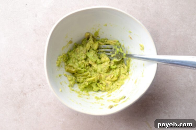 Creamy guacamole in a small bowl with a fork, ready to be served.