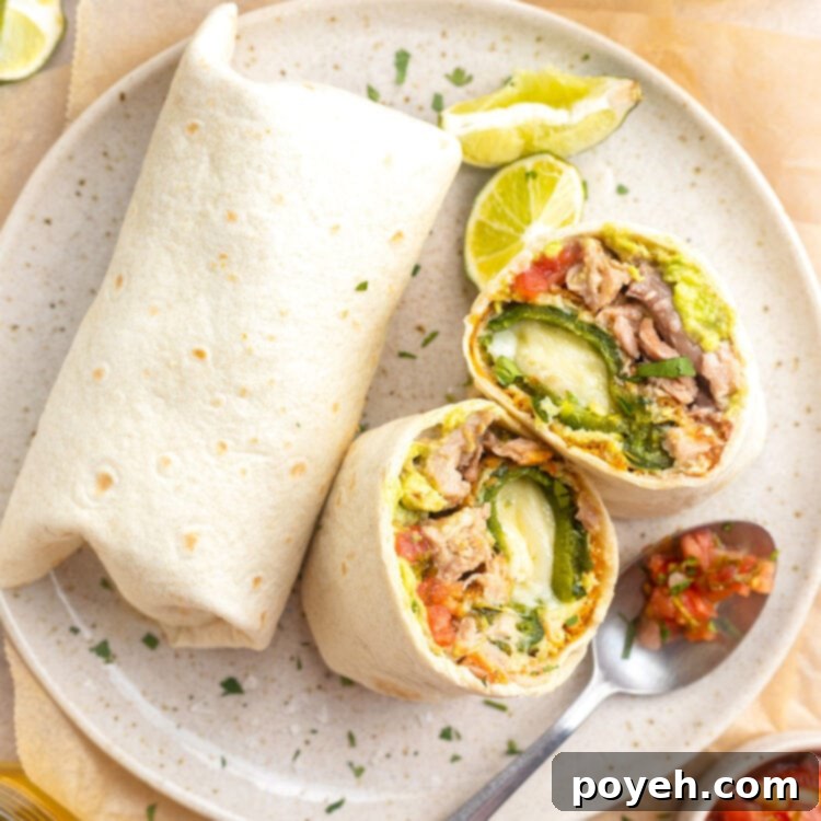 Overhead view of a chile relleno burrito cut in half and stood up on a plate, next to a whole burrito.