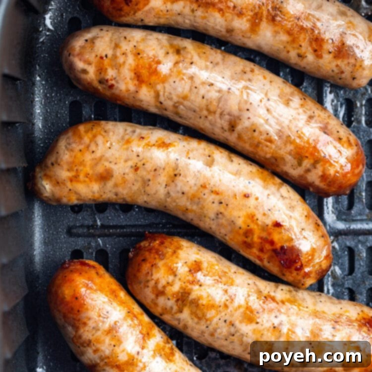 Overhead view of 5 Italian sausages in an air fryer basket.