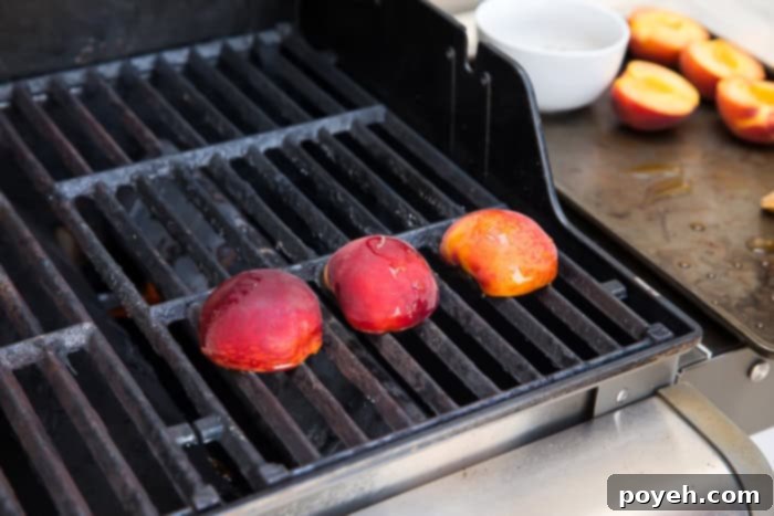 Peach halves cooking on an outdoor grill