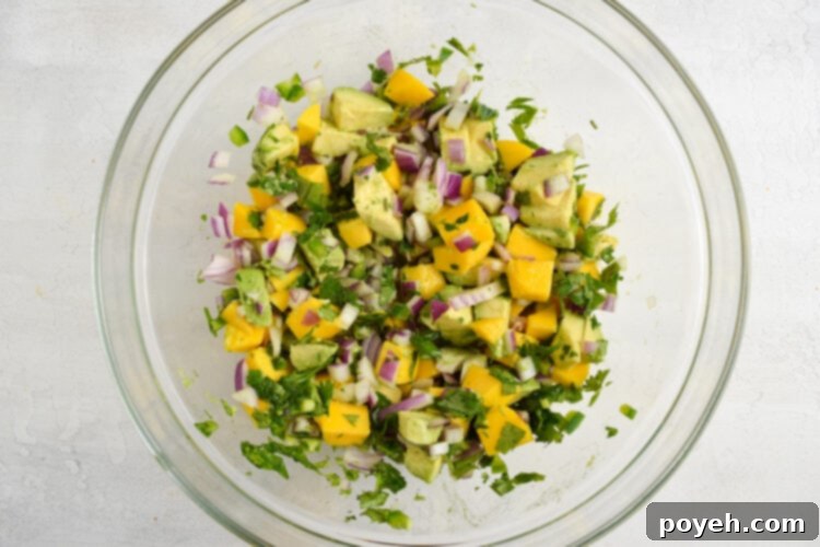 Avocado mango salsa in a glass mixing bowl.