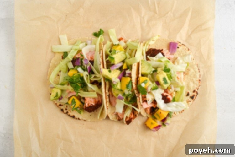Assembled salmon tacos on a sheet of parchment paper.