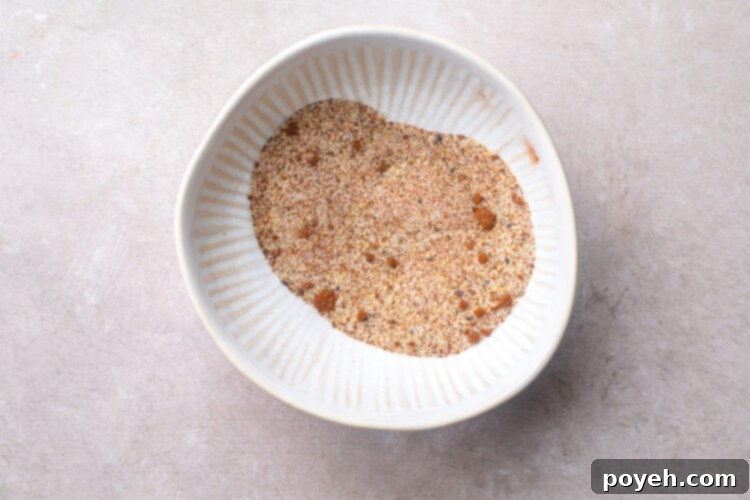 A small white bowl containing a perfectly blended spice mixture for chicken wings.