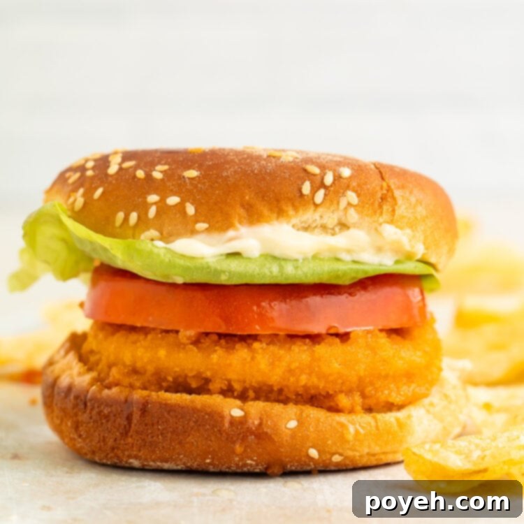 An air fryer chicken patty on a bun with a thick slice of tomato and lettuce.