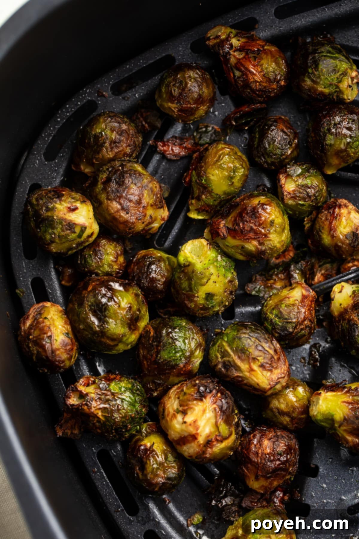 Frozen Brussels sprouts in an air fryer basket, ready to be cooked.