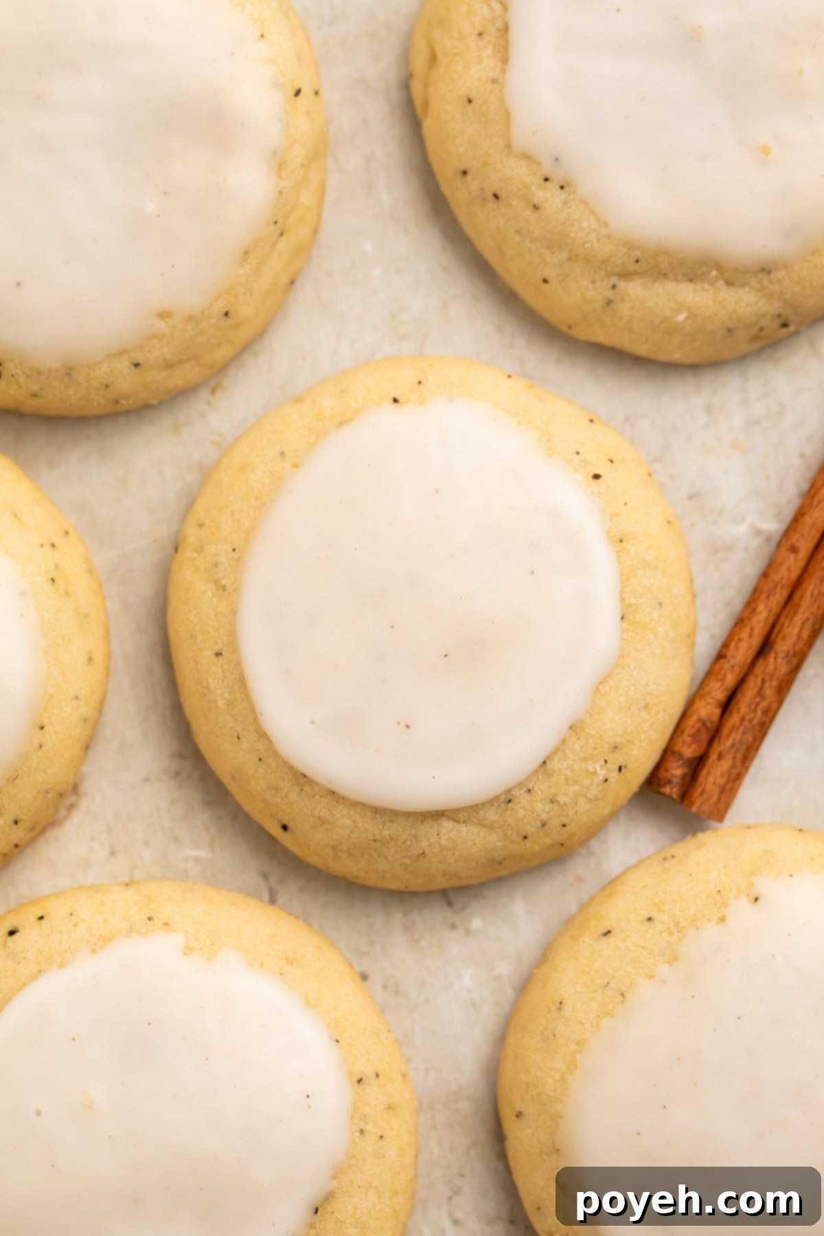 A close-up of a perfectly baked chai cookie from Taylor Swift's recipe, artfully arranged on parchment paper alongside other cookies and a fragrant cinnamon stick, highlighting its inviting texture and spice.