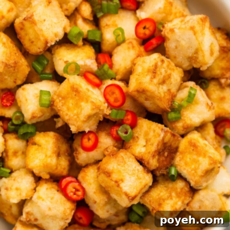 A bowl of crispy fried salt & pepper tofu with green onions and red chilies.