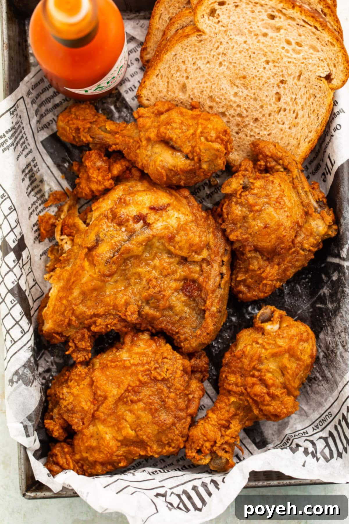 Crispy fried chicken, reheated in the air fryer, arranged neatly in a pan lined with newspaper, ready to be served.