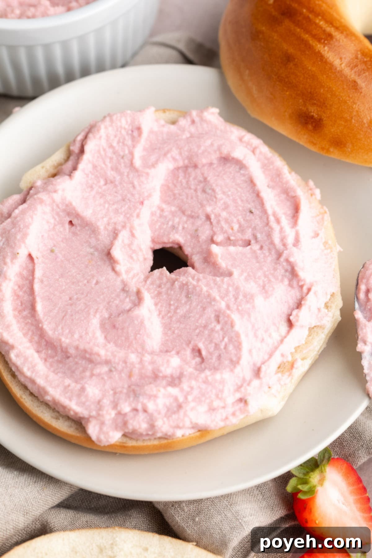 Simple Vegan Tofu Cream Cheese Four Ways 3 Mixed berry tofu cream cheese spread thickly on top of the bottom half of a bagel.