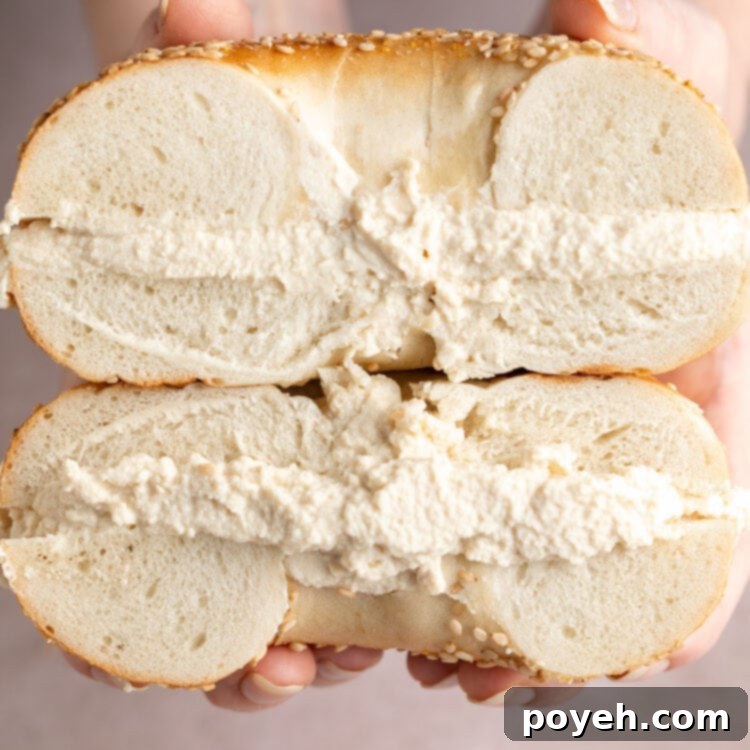 Simple Vegan Tofu Cream Cheese Four Ways 4 Thick layers of tofu cream cheese sandwiched between two bagel halves, stacked on top of each other.