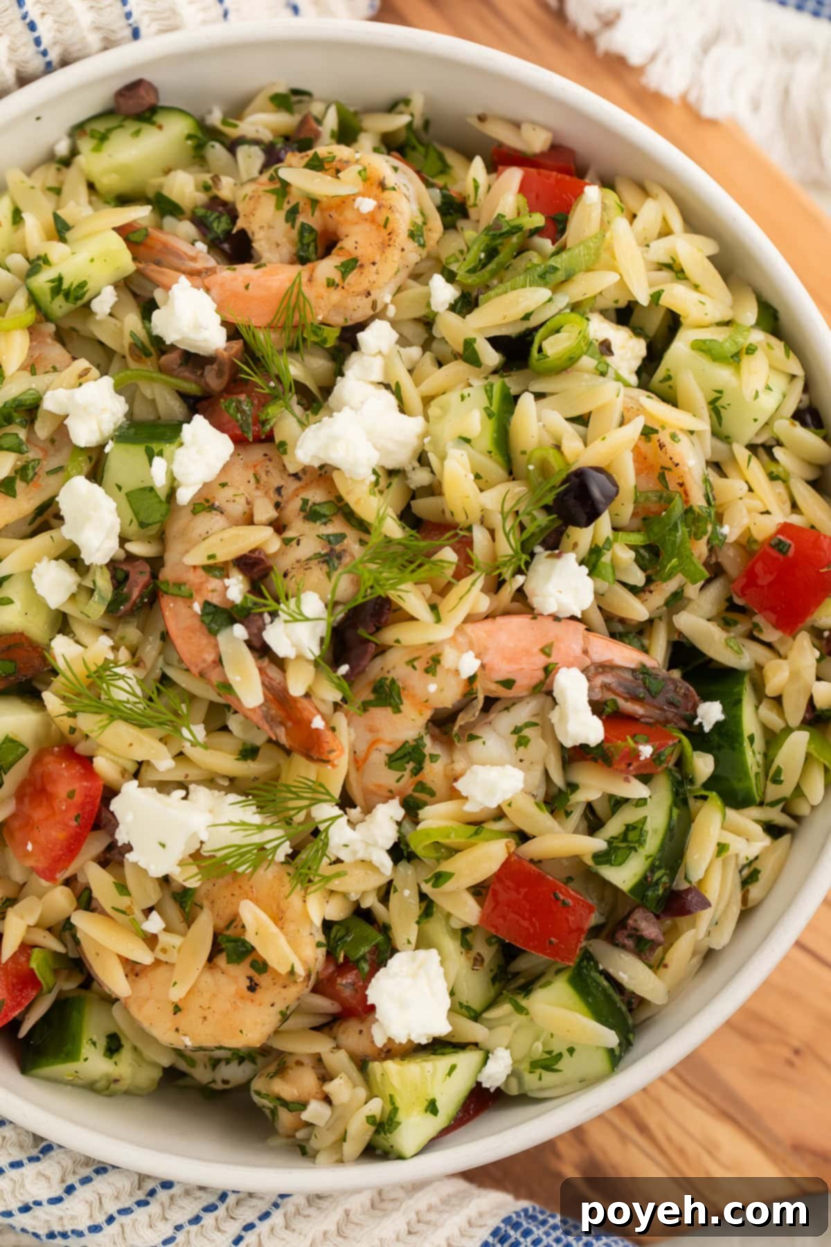 Overhead shot of a vibrant Greek shrimp and orzo salad, showcasing the colorful mix of ingredients and a zesty dressing.