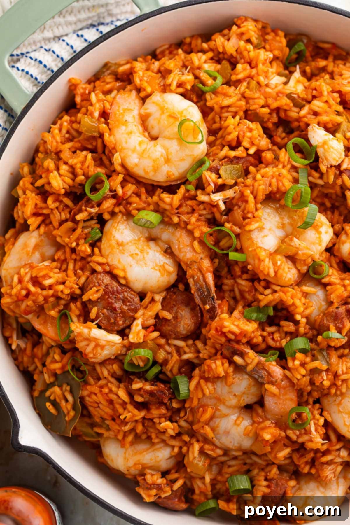 Cajun Seafood Fiesta 2 A large Dutch oven holding rich, vibrant seafood jambalaya made with luscious shrimp and tender rice, garnished with fresh herbs.