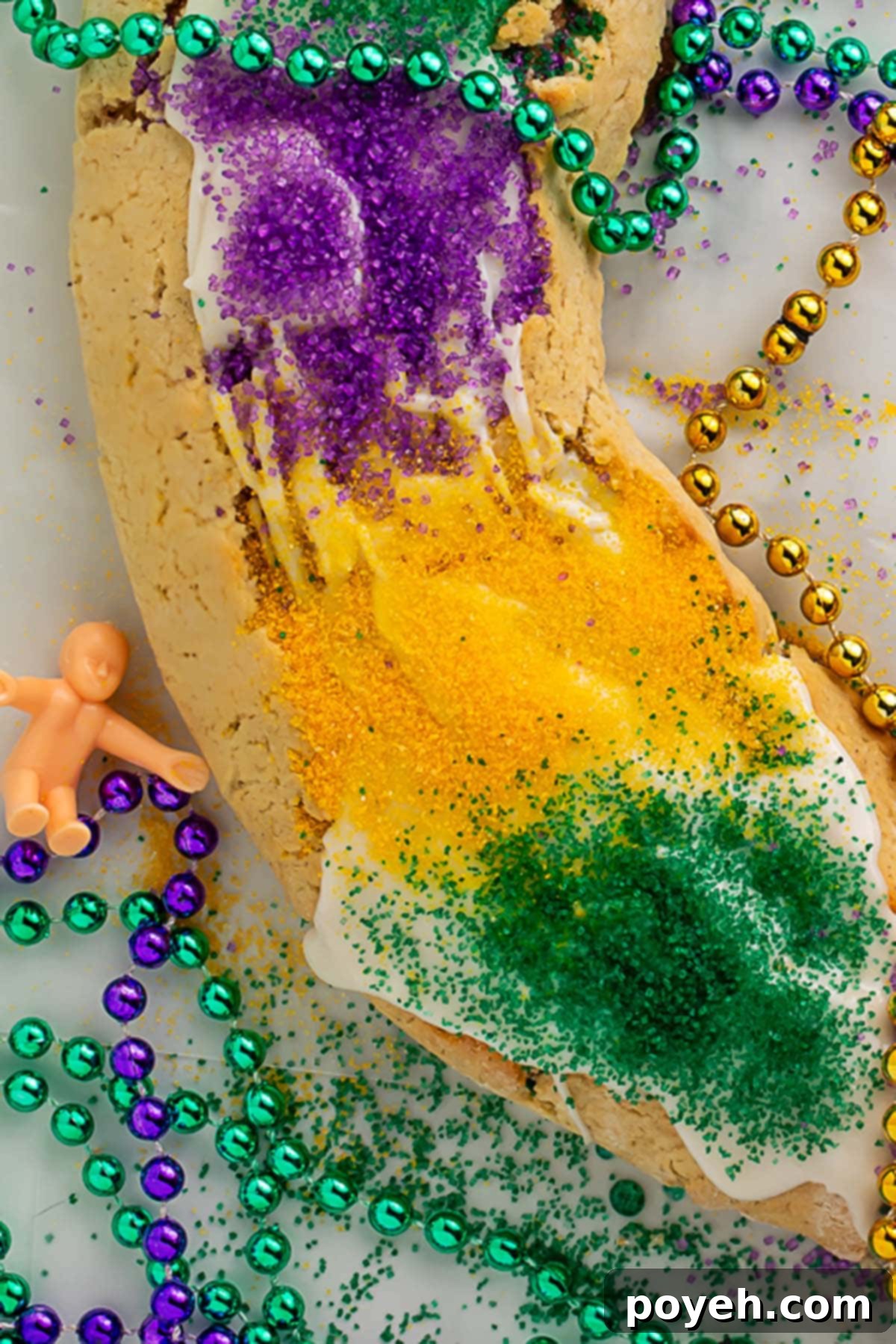 Close-up of a king cake baby next to a gluten-free king cake.