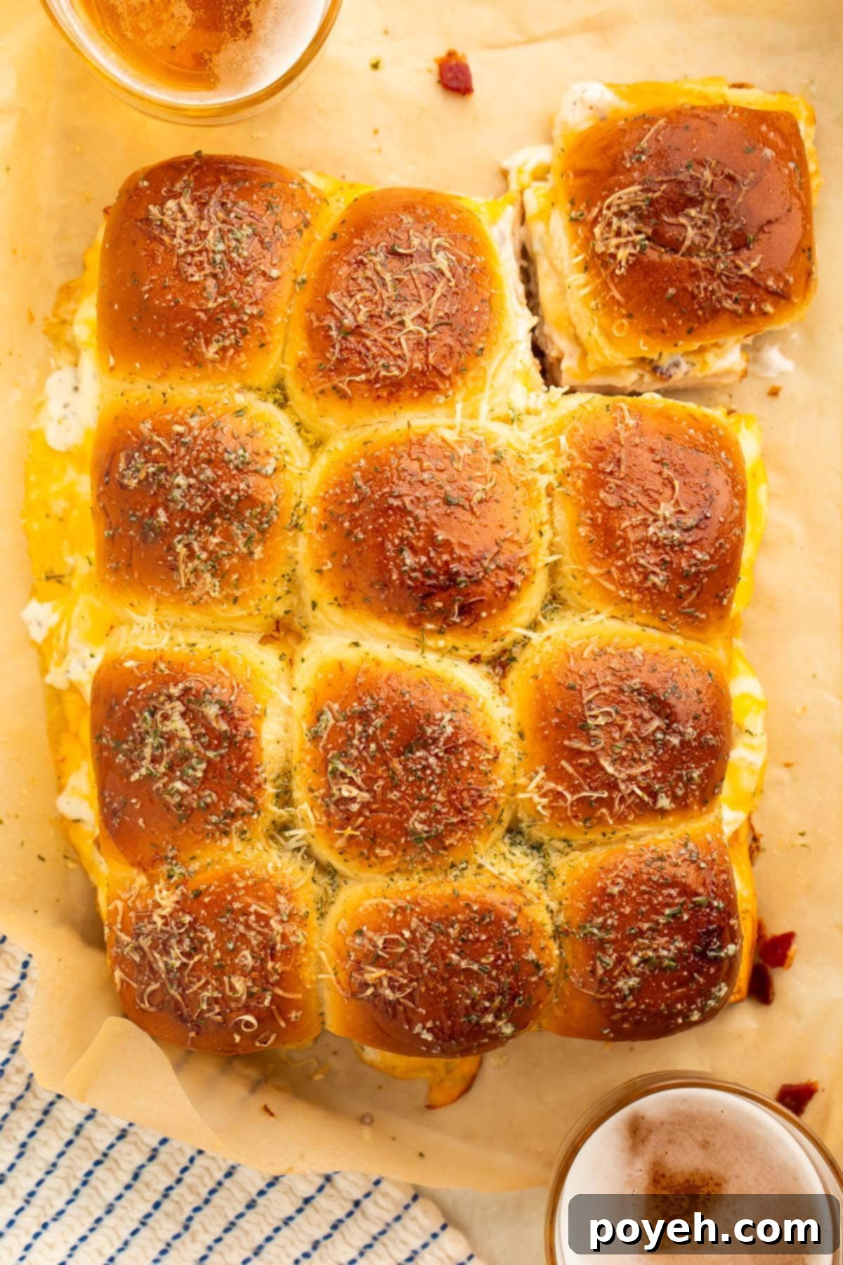 A baking sheet filled with 12 golden-brown Chicken Bacon Ranch Sliders, ready to be served, photographed from above to show their perfect size and toasted tops.