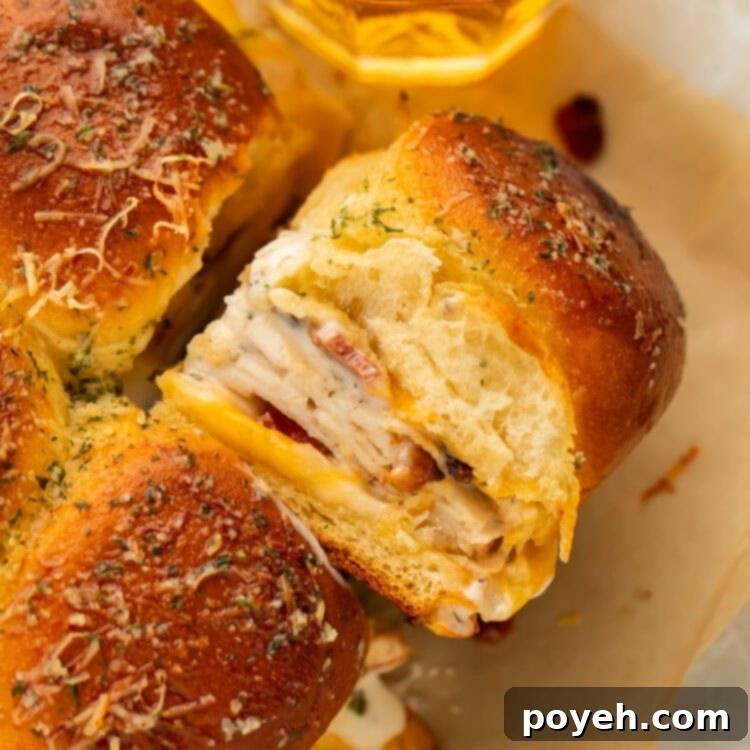 A close-up of a chicken bacon ranch slider, showcasing the warm, golden-brown Hawaiian roll and the delicious filling within.