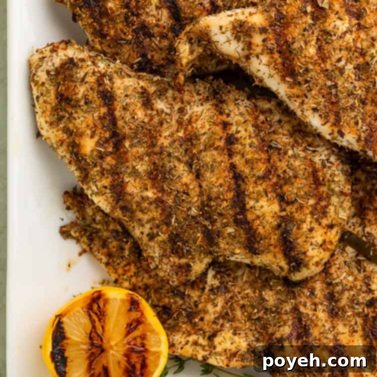 Close-up of Texas Roadhouse herb-crusted chicken on a large white rectangular platter.