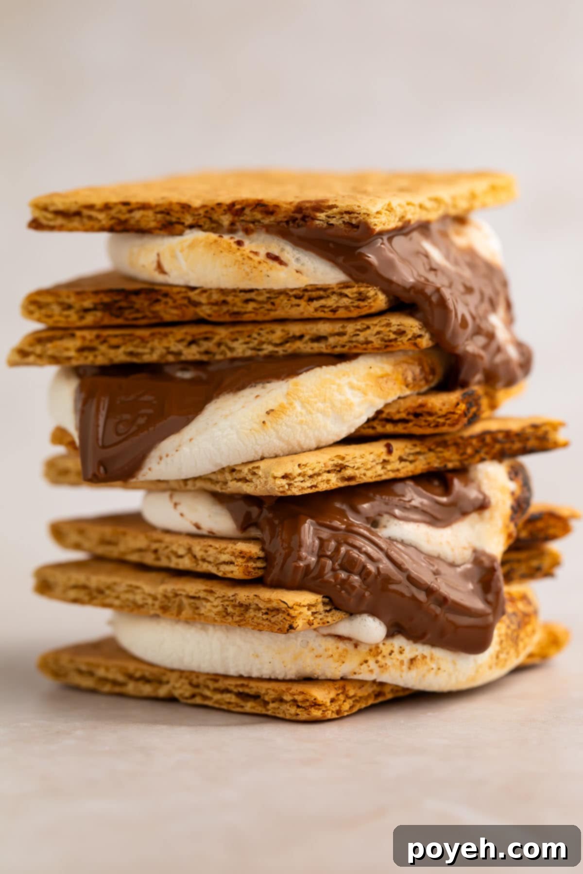 Three perfectly stacked air fryer s'mores, showing golden-brown marshmallows, melted chocolate, and graham crackers.