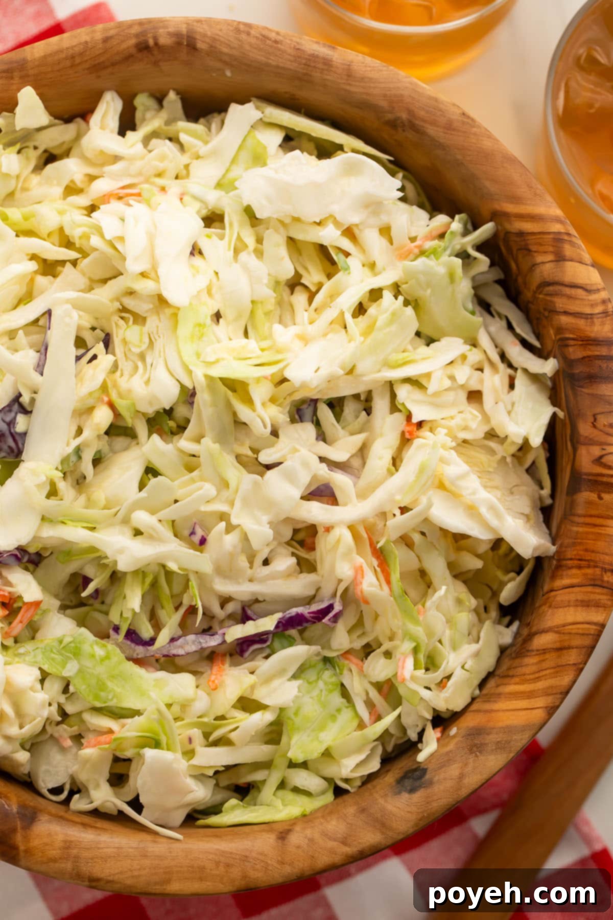 Creamy Plant-Based Slaw 2 Close-up of a wooden bowl holding vegan coleslaw, showcasing its creamy texture and fresh ingredients.