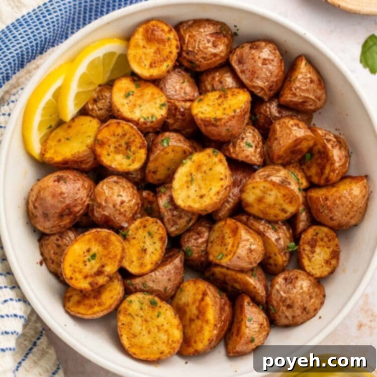 A bowl of air fryer red potatoes with 2 lemon slices.