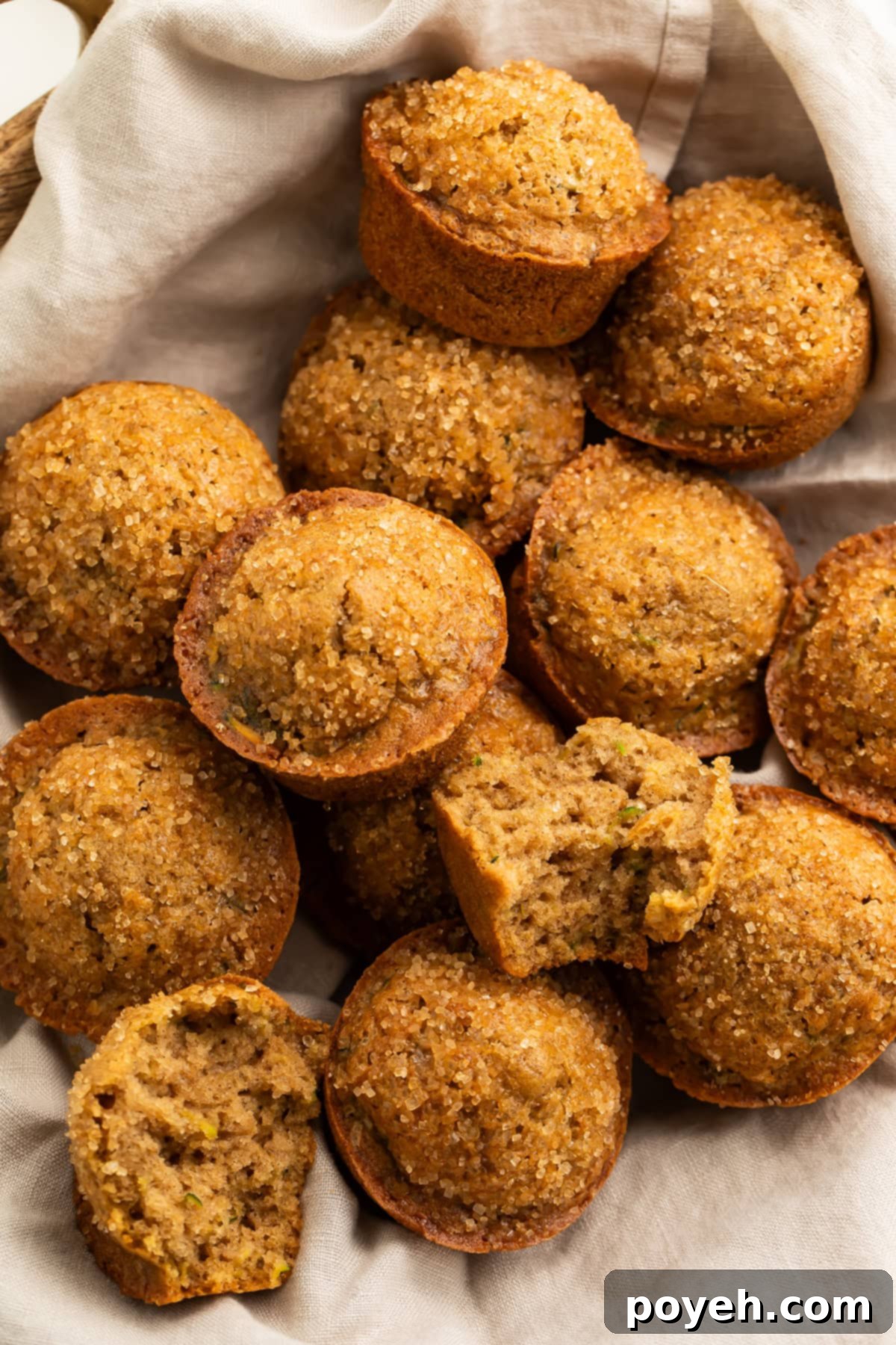 A linen-lined basket showcasing a collection of warm, gluten-free zucchini muffins, ready to be enjoyed.