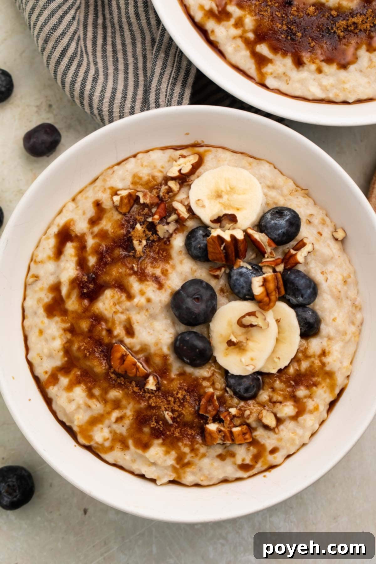 A large bowl of creamy Instant Pot Oatmeal topped with chopped pecans, sliced bananas, and fresh blueberries.
