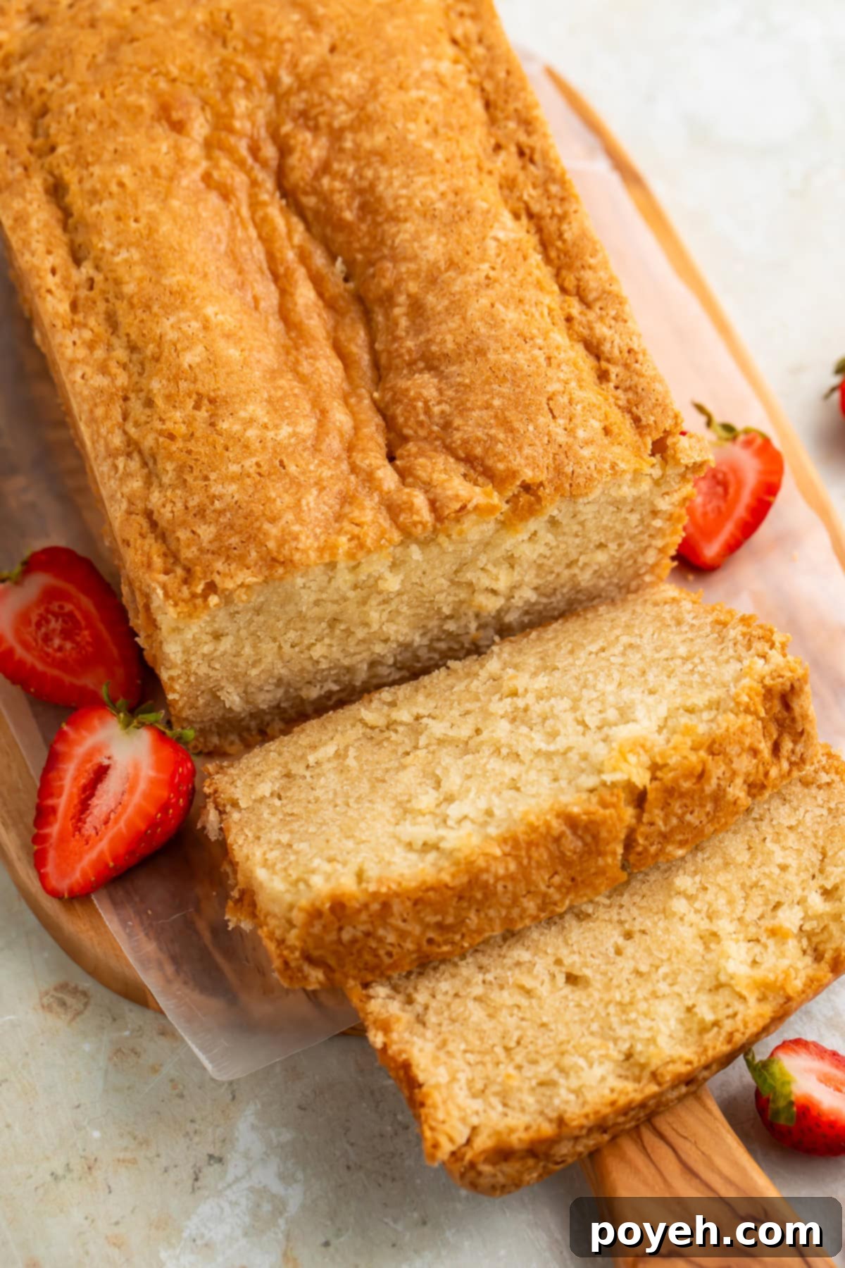 Top down picture of a sliced pound cake on a wooden board.