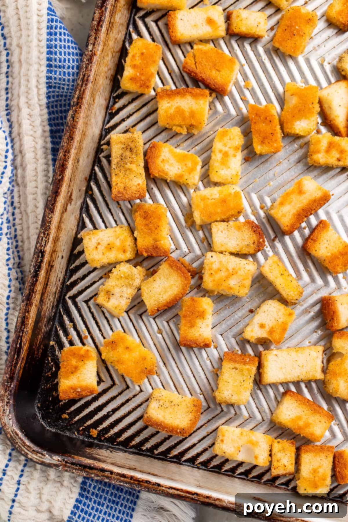 Close up of perfectly golden and crispy gluten-free croutons on a baking sheet, ready to be enjoyed.
