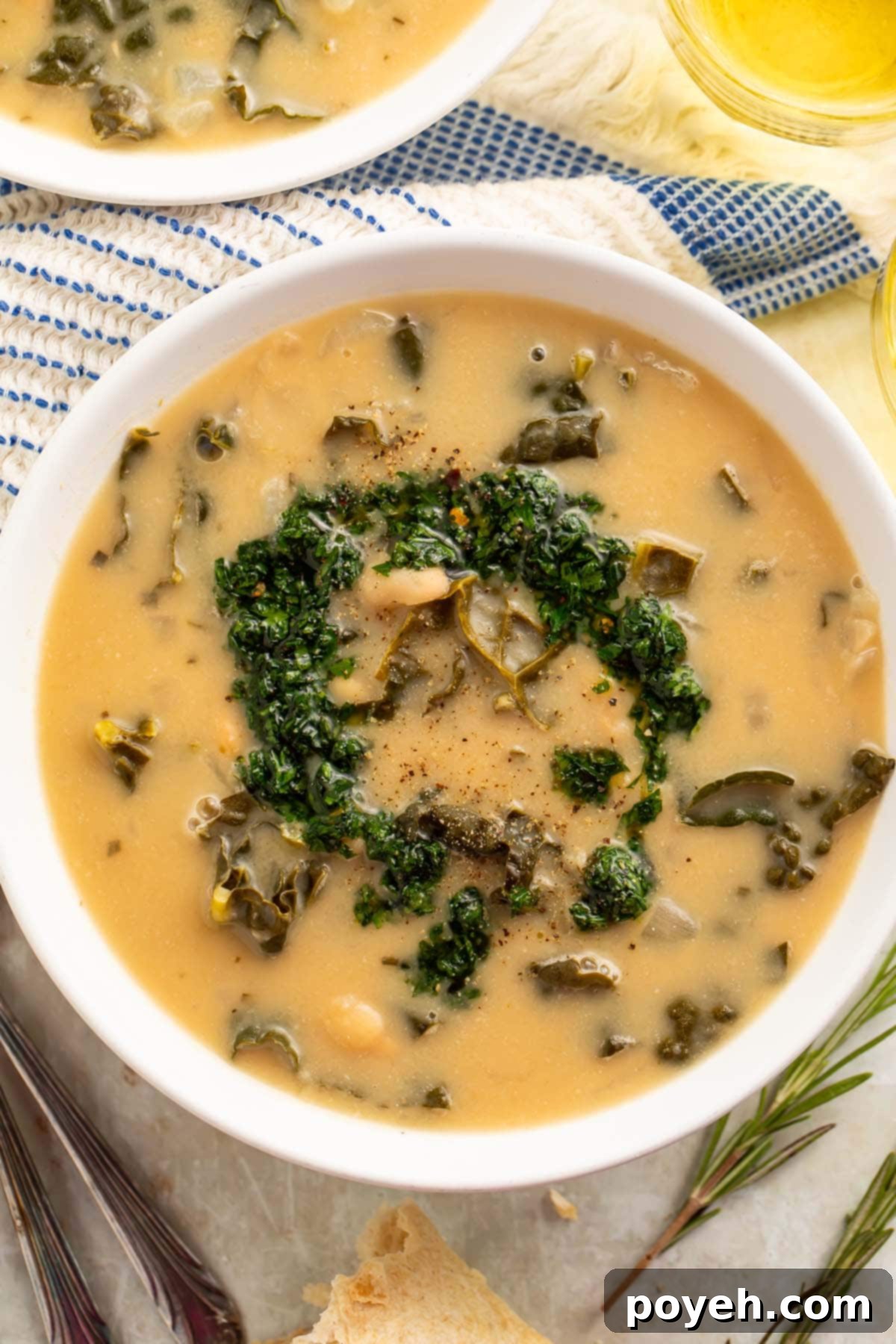 Top-down view of a bowl of creamy kale and white bean soup finished with gremolata.