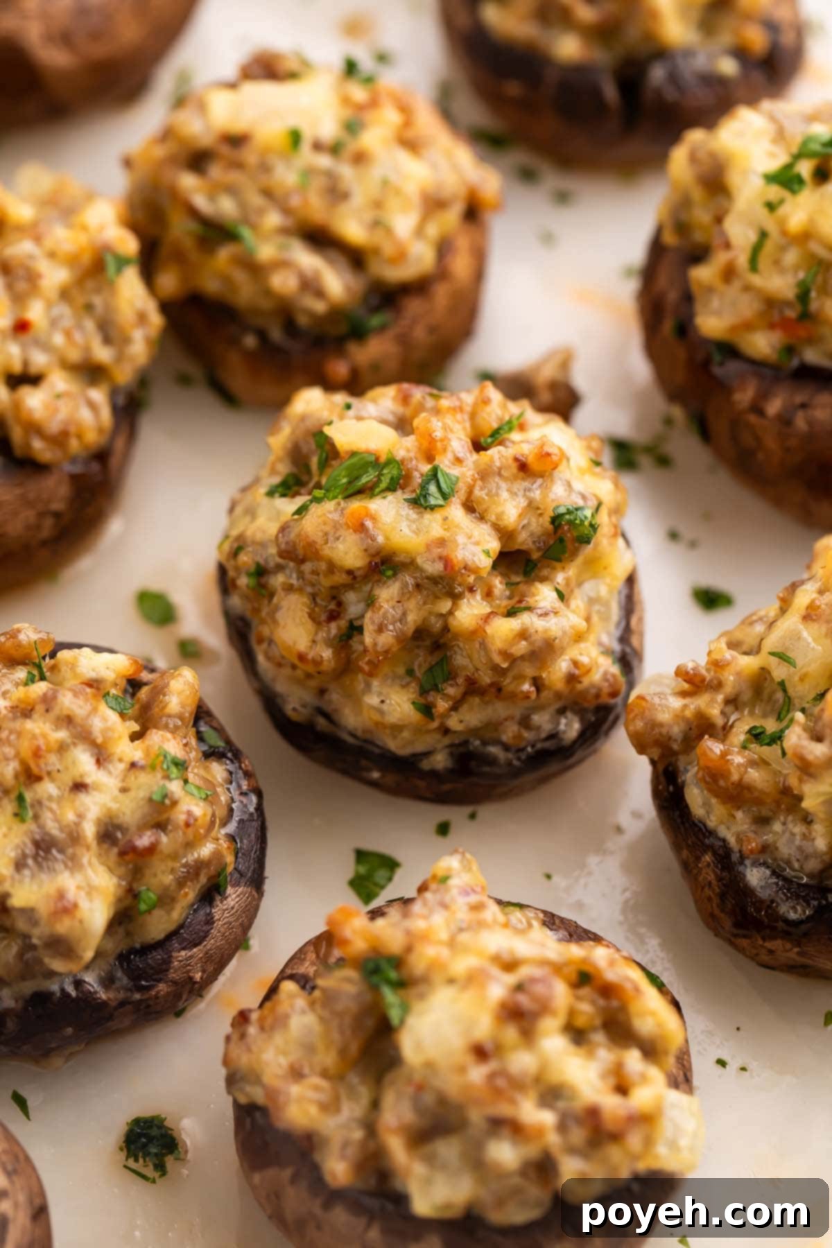 Close-up on a sausage stuffed mushroom on a platter with other stuffed mushrooms.