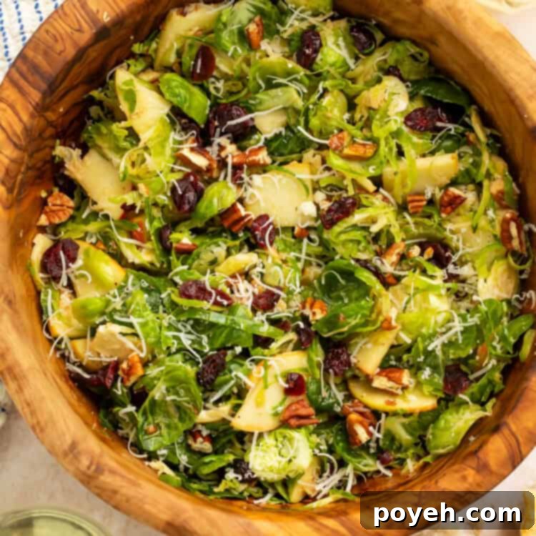 Wooden bowl of a shredded brussels sprouts salad.