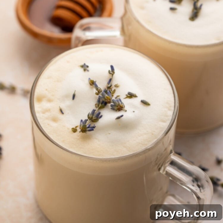 A London fog latte in a clear glass mug sitting on a table.